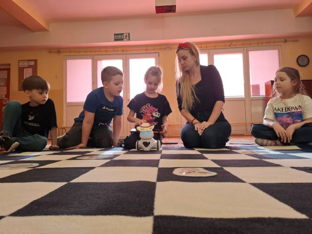 dzieci siedza na dywanie