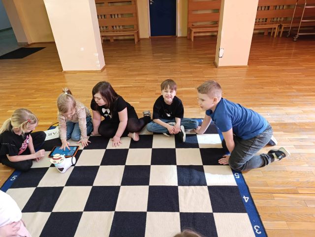 dzieci siedza nadywanie z robotem