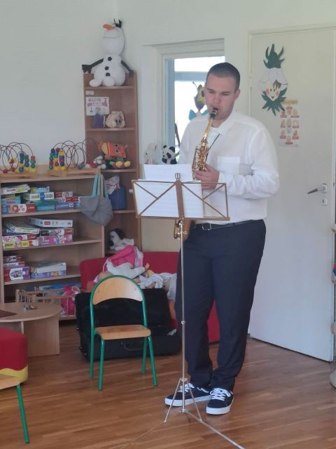 chlopiec gra na saksofonie