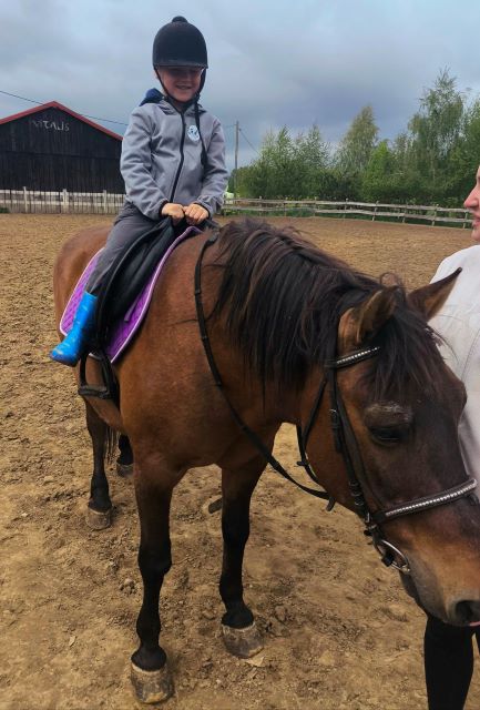 chlopczyk siedzi na koniu